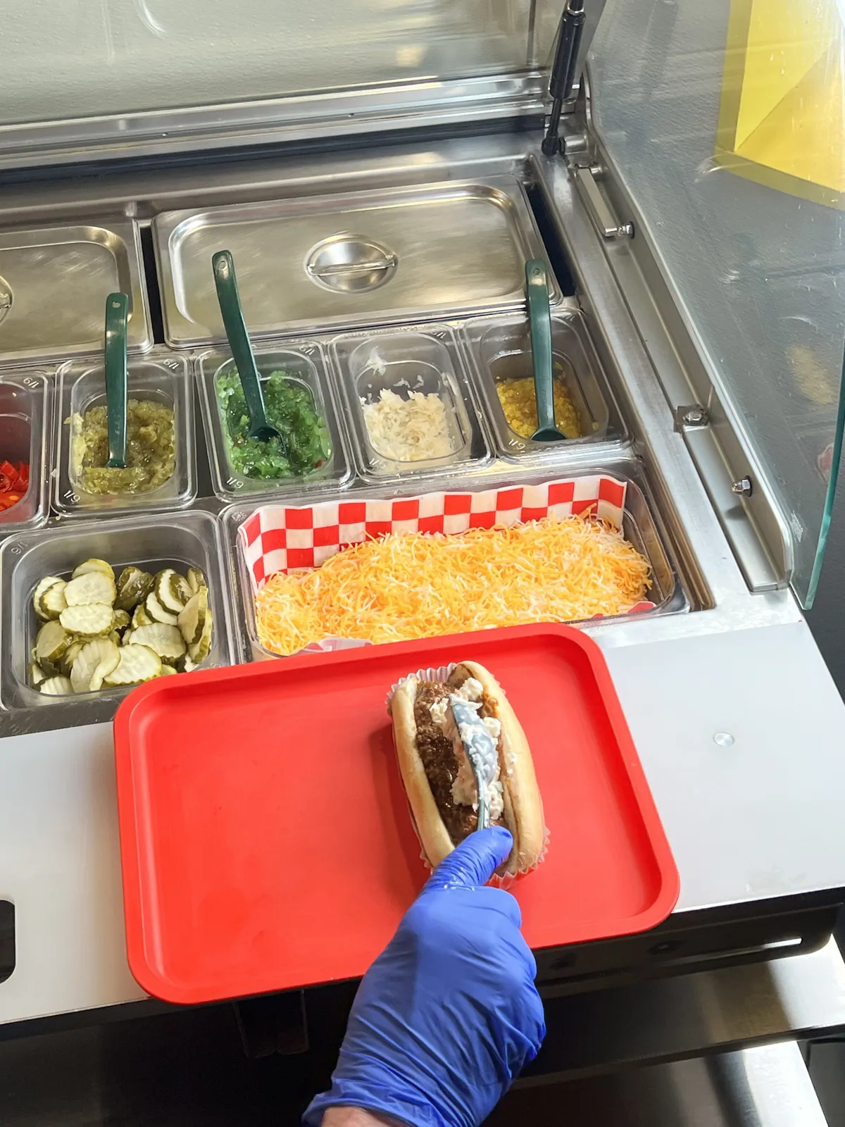 Building a dog at the toppings counter