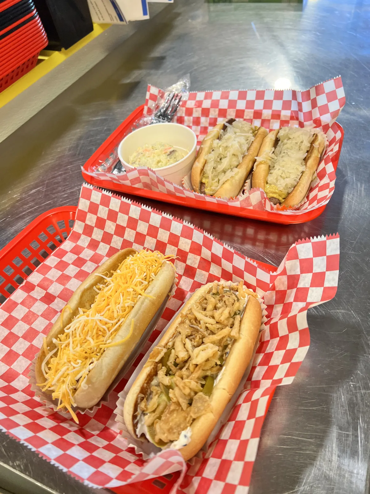 Baskets of dogs with cheese, fried onions, and a side of slaw